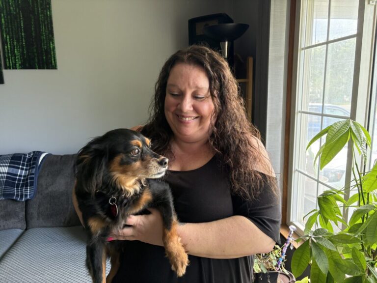 Marie Noon at her home in Brighton, Mich., with her dog, Ziggy. Despite being eligible for Medicaid, Noon was denied coverage in 2025 because of an error with the state’s benefits system. It took months of pushback before the state reversed its mistake. Even as a “tech-savvy” former bank manager, Noon says, she wanted to give up several times along the way.