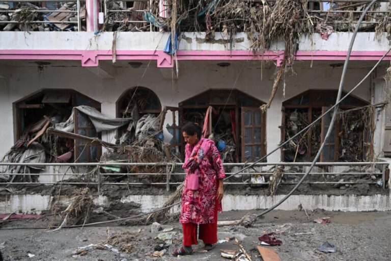 A woman salvages usable materials from her house deluged in sludge following flash floods at Devighat in Nepal's Nuwakot district.