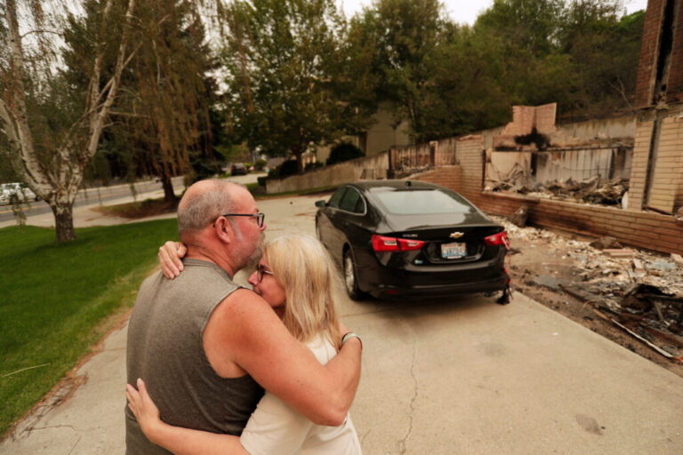 Allen Sather and his wife Kimberley embrace at the duplex they rent on W. Indian Trail Rd. after it burned in a wildfire in Spokane, Wash., Sunday, Aug. 2, 2026.