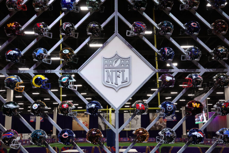 The NFL logo is surrounded by helmets of the 32 teams in the league. A new survey released Monday found that a third of former NFL players believe they have CTE, a degenerative brain disease linked to concussions.