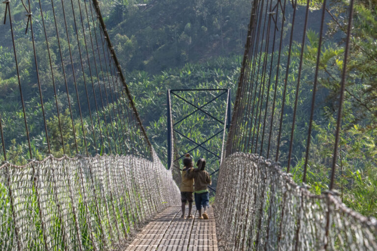 Two kids cross the Cyangoga Suspension bridge built by Fika.