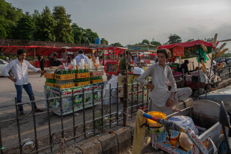 Men sell food and drinks outside Bari Imam on August 20, 2026 in Islamabad, Pakistan. Businesses around the shrine were destroyed along with homes during a demolition drive last winter and spring.
