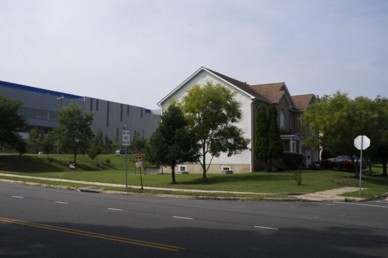 A long Vantage data center building stands behind residential buildings in Sterling, Virginia.