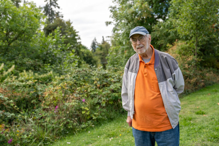 Harry Keaton Moore Jr., 84, Buster's nephew, is wearing a baseball hat and a jacket over an orange shirt.