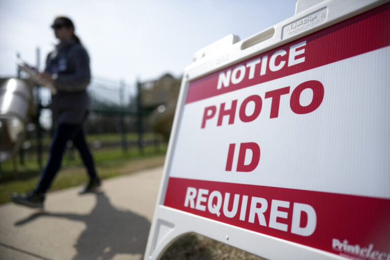A voter walks past a sign that says