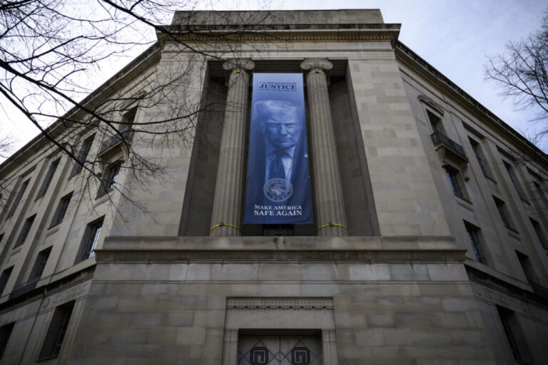 A banner of an image of President Trump is displayed on the facade of the U.S. Department of Justice headquarters in Washington, D.C., in February 2026.