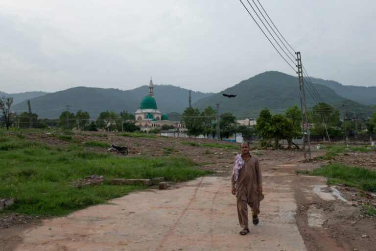 A man walks through an area where houses were demolished near Bari Imam on August 19, 2026 in Islamabad, Pakistan.