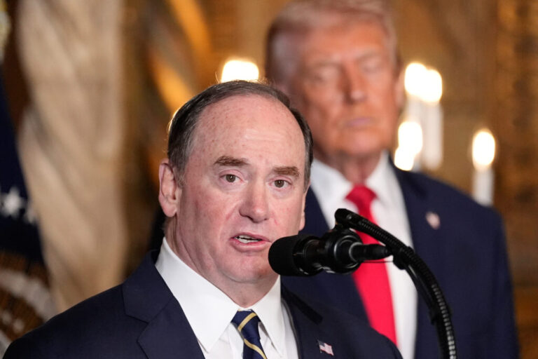 Secretary of the Navy John Phelan speaks, as President Trump listens, at Trump's Mar-a-Lago club on Dec. 22 in Palm Beach, Fla.