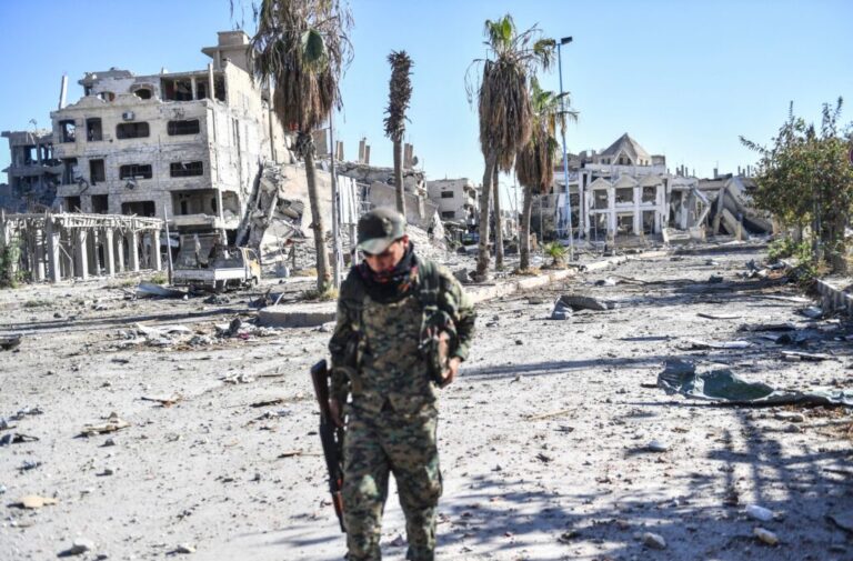 A member of the Syrian Democratic Forces (SDF) walks through a heavily damaged a street leading to an Armenian church in Raqa on October 18, 2017. The SDF fighters flushed jihadist holdouts from Raqa's main hospital and municipal stadium, wrapping up a more than four-month offensive against what used to be the inner sanctum of IS's self-proclaimed