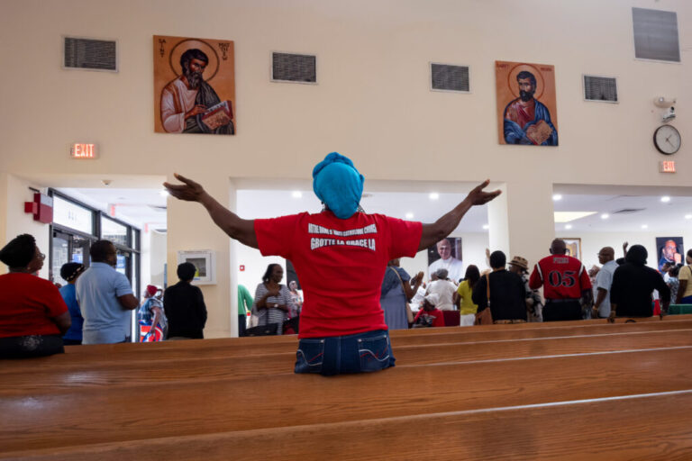 A woman raises her hands in prayer during a St. Michel prayer gathering at Notre Dame d'Haiti Catholic Church on Wednesday, Sept. 2, 2026, in the Little Haiti neighborhood of Miami, Fla.