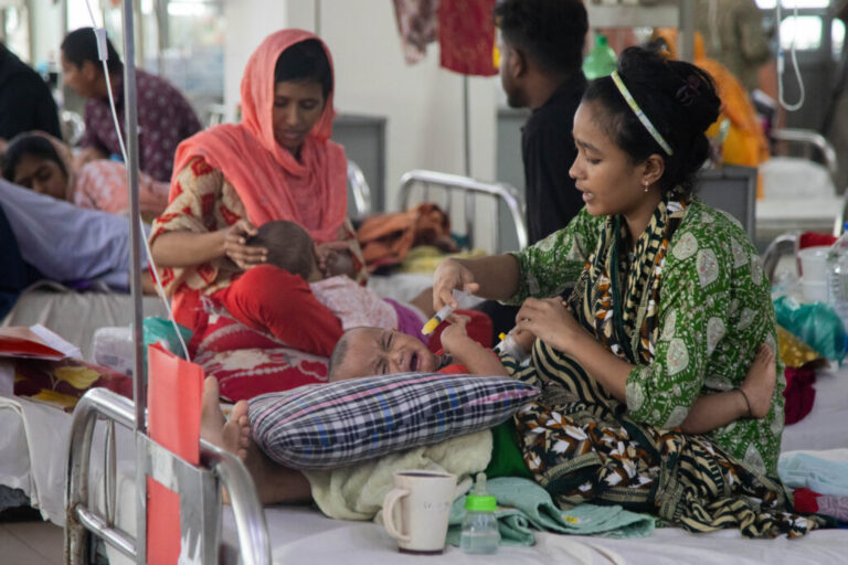 Thirteen-month-old Jannat cries as her mother Sohana, a garment worker, tries to feed her. The child is hospitalized for measles at DNCC Hospital in Dhaka, Bangladesh.