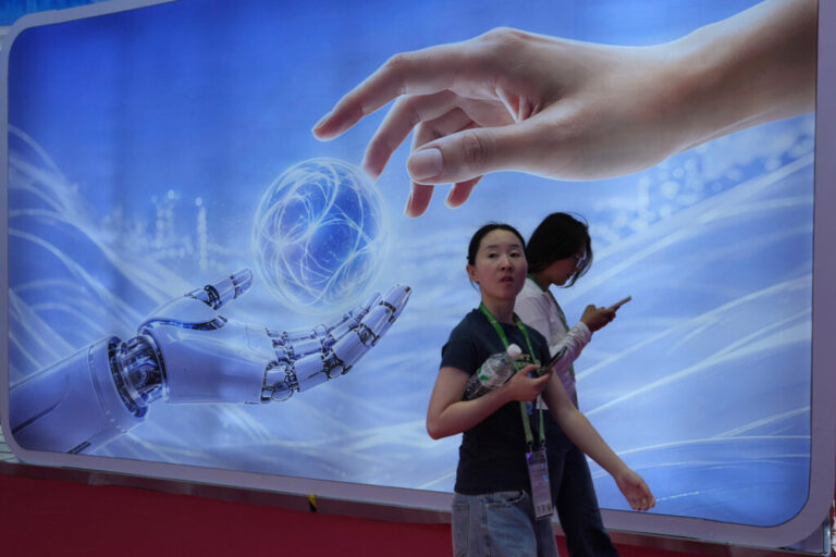 Visitors walk past a display depicting artificial intelligence and a human hand at the China International Supply Chain Expo in Beijing on June 22.