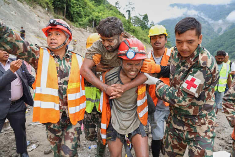 In this photo provided by the Nepal Army, soldiers rescue a worker alive from a tunnel during an ongoing operation at the Trishuli-3A hydropower project in Nepal's Rasuwa district, Friday.