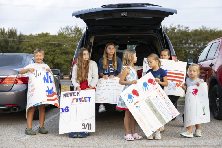 Brooks Penny, 9, Harper Penny, 12, Mabrey Penny, 11, Isla Penny, 6, Charlotte Zwolinski, 6, Kensie Zwolinski, 9, and Madelyn Zwolinski, 4, holds their posters up for the Austin fire fighters during the annual Austin Fire Department Memorial Stair Climb at Pleasant Valley Tower on Friday. Austin firefighters climbed the tower until they reach 1,386, the height of the World Trade Center, to pay tribute to firefighters who died on 9/11.
