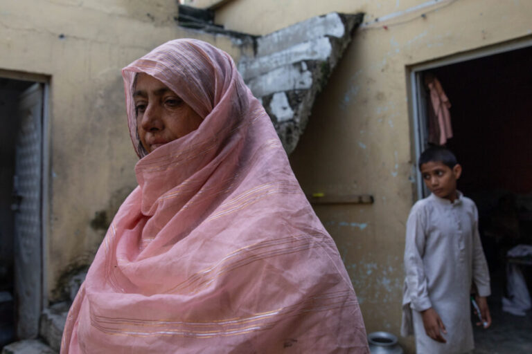 Saida Tanvir stands inside her partially damaged home near Bari Imam on August 20, 2026 in Islamabad, Pakistan. Her son Azeem Ahmed, 16, died while trying to block a bulldozer from crushing their roadside grocery store over the winter.
