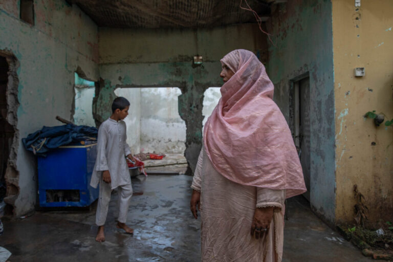 Saida Tanwir stands inside her partially damaged home near Bari Imam on August 20, 2026 in Islamabad, Pakistan. Her son Azeem Ahmed, 16, died while trying to block a bulldozer from crushing their roadside grocery store over the winter.