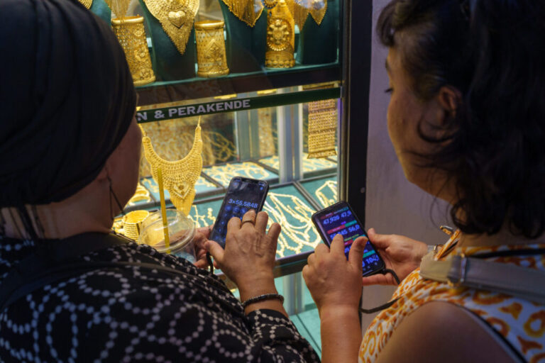 Women use their phones to calculate exchange rates before buying gold at the Grand Bazaar in Istanbul, Turkey, on Aug. 20, 2026.