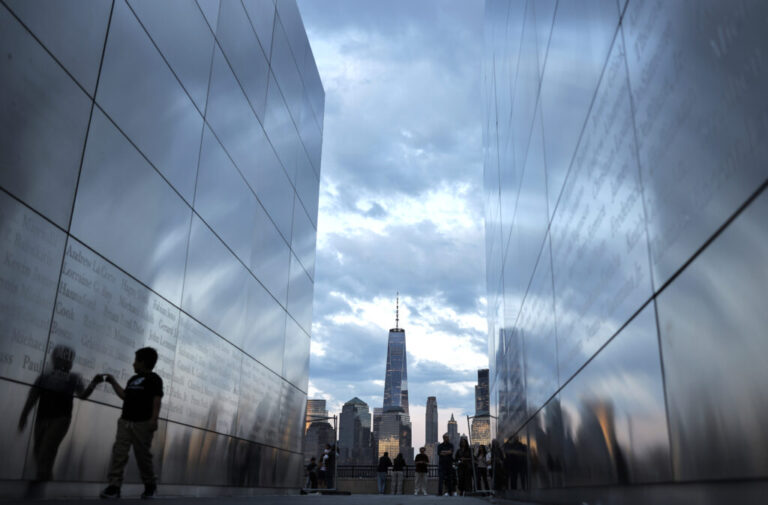 A child walks between the twin parallel walls of Empty Sky, the 9/11 memorial in Jersey City, New Jersey, on August 23. In the background are One World Trade Center and other tall buildings in Lower Manhattan.