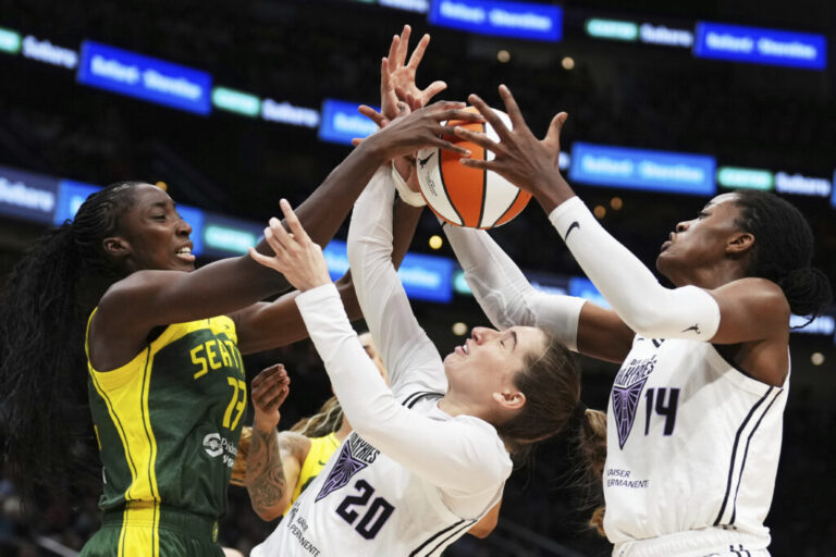 Golden State Valkyries guard Kate Martin (20) struggles to maintain possession against Seattle Storm forward Ezi Magbegor (left) as Valkyries center Temi Fagbenle (14) reaches for the ball during the second half of a WNBA game Wednesday in Seattle. The Valkyries debuted this season as the league's 13th team.