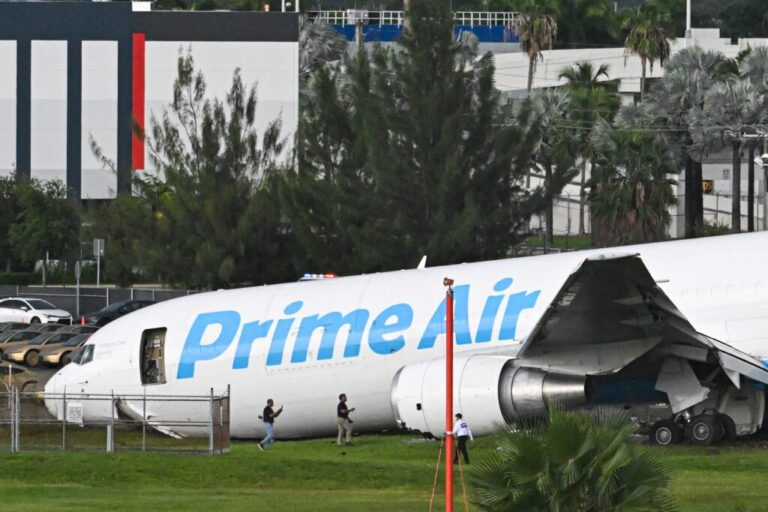 Officials investigate a Prime Air cargo plane at Miami International Airport after it overran the runway at Miami International Airport in Miami, Florida, on Sept. 6, 2026. An Amazon cargo plane overshot a runway as it landed in Miami, crashing into vehicles and catching fire, officials said.