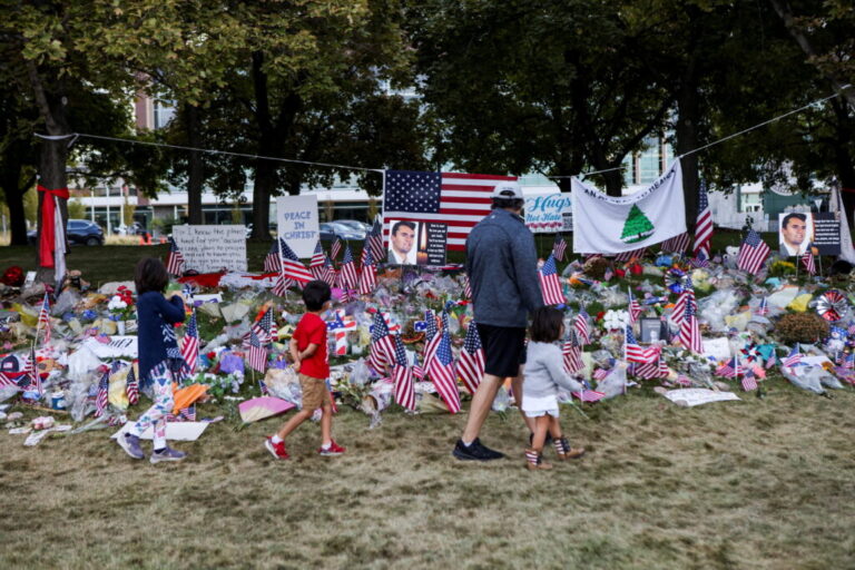 People walk in front of a memorial for slain conservative commentator Charlie Kirk, at Utah Valley University in Orem, Utah, on September 29, 2025.