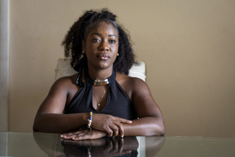 Herlain, who asked NPR to withhold her last name, poses for a portrait at her home in North Lauderdale, Fla.