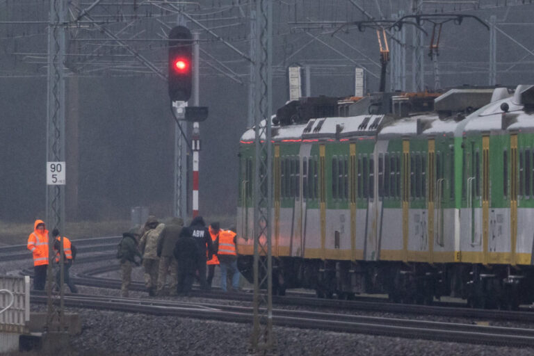 Investigators examine a rail line damaged in an explosion in Mika, Poland, on November 17, 2025.