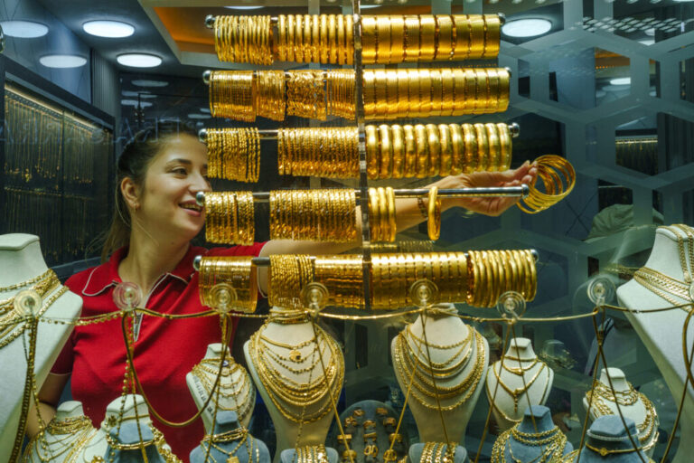 A female jeweler takes gold bracelets from a display case at the Grand Bazaar to show them to customers in Istanbul, Turkey, on Aug. 20, 2026.