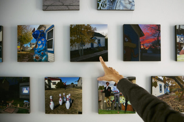 Daryl McCool points to photographs displayed in her rebuilt home in Superior, Colorado. McCool lost the small, single-story historic miner’s shack where she and her family had lived for 25 years when it was destroyed in the Marshall Fire on Dec. 30, 2021. The fire is part of the broader climate-related costs facing Colorado communities.