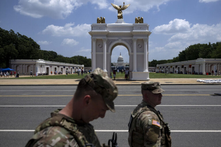 National Guard Members walk near a replica of President Trump's proposed arch at the Great American State Fair on the National Mall in Washington, DC, in July.