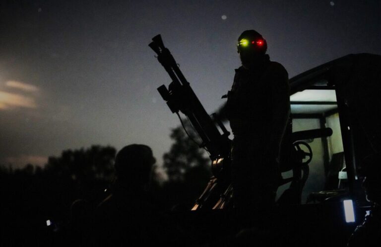 A Ukrainian soldier stands ready to defend against a Russian drone attack.