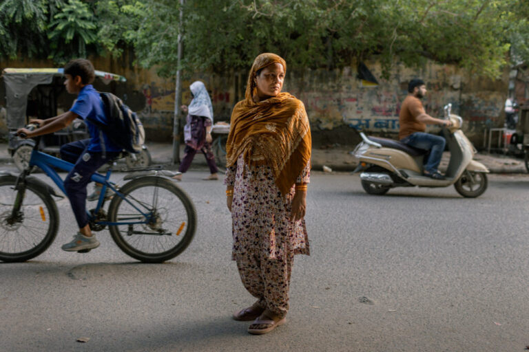 NEW DELHI, INDIA - OCTOBER 13, 2026: Malika, a cleaning lady, poses in the Muslim-majority neighborhood of Mustafabad in New Delhi, India, October 13, 2026. Malika was a witness to the 2020 Hindu-Muslim riots, and recently her name has been removed from the voter list amid the Election Commission of India's Special Intensive Revision (SIR), a voter-roll verification exercise that has led to the removal of millions of names across India. Elke Scholiers for NPR The communal violence in Mustafabad was part of the February 2020 Northeast Delhi riots, one of the deadliest episodes of communal violence in India's capital in recent decades. The immediate backdrop was intense political conflict over the Citizenship (Amendment) Act (CAA), passed in December 2019.