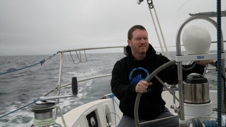 Sailor Matt Rutherford at the helm of a sailboat. He hopes to be the first to circumnavigate the Arctic Circle alone.