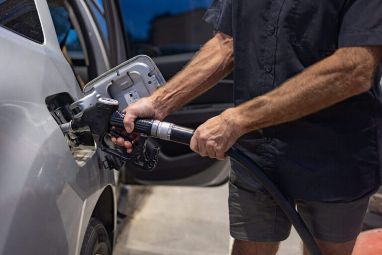 A man pumps gas at a gas station.