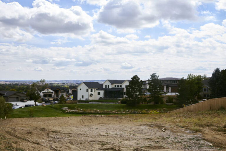 A newly rebuilt home stands next to an empty lot in the Louisville neighborhood. Wildfires are among the climate-related impacts Boulder County cites in its lawsuit against ExxonMobil and Suncor Energy.