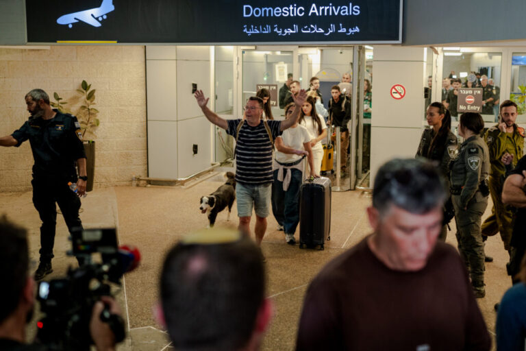 TZAFRIA, ISRAEL - SEPTEMBER 30: A passenger raises his arms in relief as he walks through the domestic arrivals doors with his dog and luggage at Ben Gurion Airport on September 30, 2026 in Tzafria, Israel. A flydubai flight from Dubai to Tel Aviv was diverted to Saudi Arabia after a violent altercation in the cockpit.