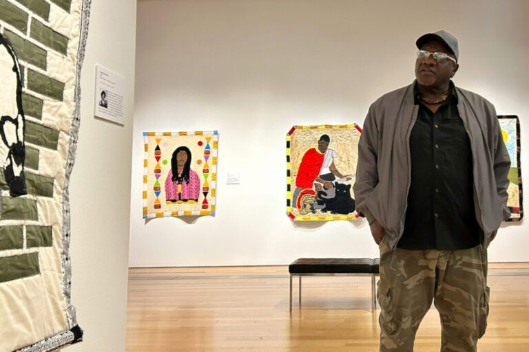Gary Tyler speaks about his work at the Grand Rapids Art Museum in Michigan. Behind Tyler are his quilts Big Toe, (2024) and Enduring, (2025). They feature two individuals who are incarcerated. He hopes his work draws attention to their plight and humanity.